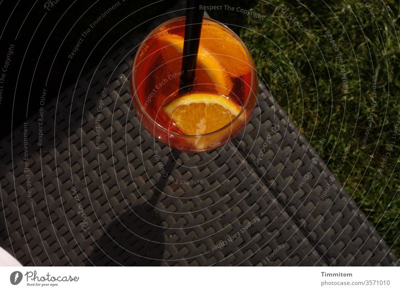 Der Drink wartet in der Abendsonne Glas Strohhalm Alkohol Feier trinken Orangenscheibe Getränk Cocktail orange Licht schwarz dunkel