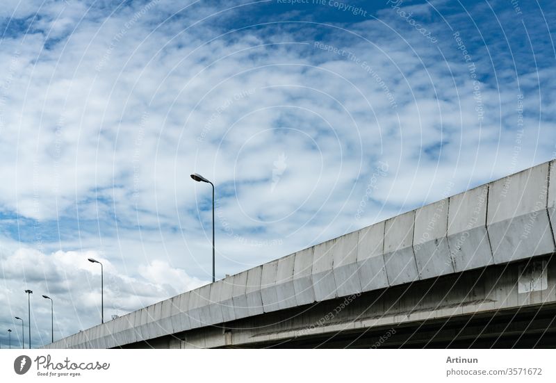 Erhöhter Betonstraßen- und Straßenlampenmast. Betonstraße überqueren. Straßenüberführung. Moderne Autobahn. Verkehrs-Infrastruktur. Konstruktion von Betonbrücken. Brückenarchitektur.