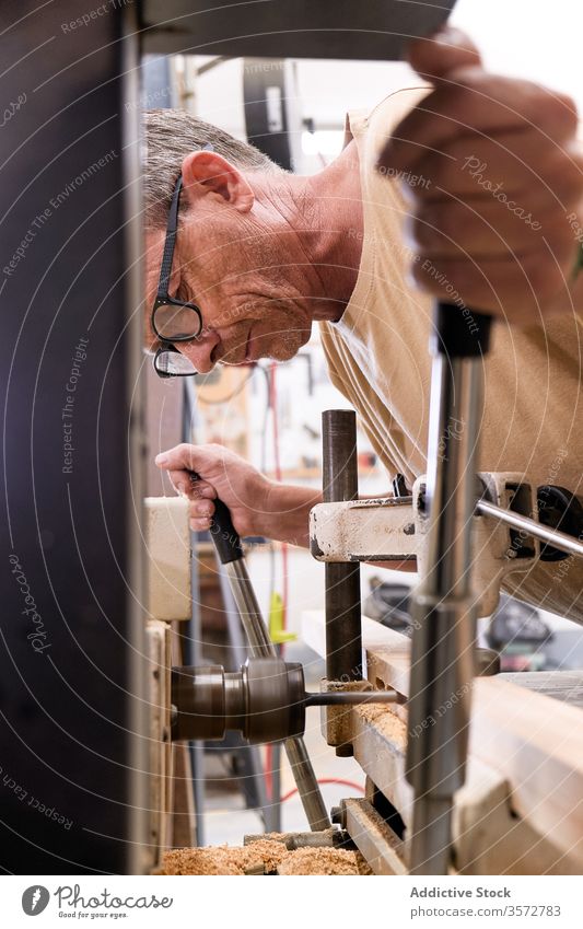 Fleißiger Zimmermann bohrt Holz in modernem Arbeitsraum Zimmerer bohren Schreinerei Nutzholz Holzarbeiten Verarbeitung Kunsthandwerk Mann Werkstatt Arbeitsplatz