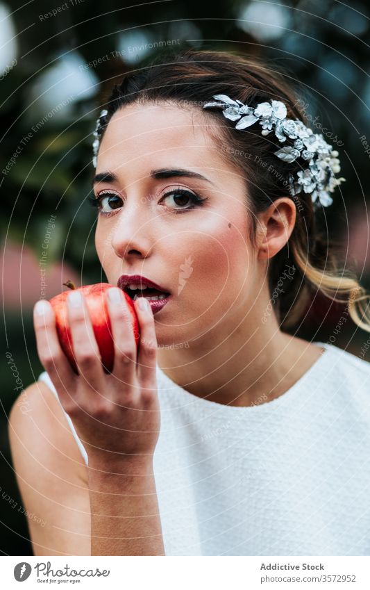 Junge Braut isst Apfel vom Brunnen Frau Springbrunnen Garten elegant jung frisch Hochzeit Biss Model Frucht Wasser nass Schalen & Schüsseln Sommer Park Stil