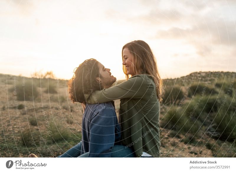 Freudiges Paar umarmt sich bei Sonnenuntergang in der Natur Spaß Termin & Datum Umarmung Liebe Zusammensein Partnerschaft Glück Mann Frau romantisch heiter