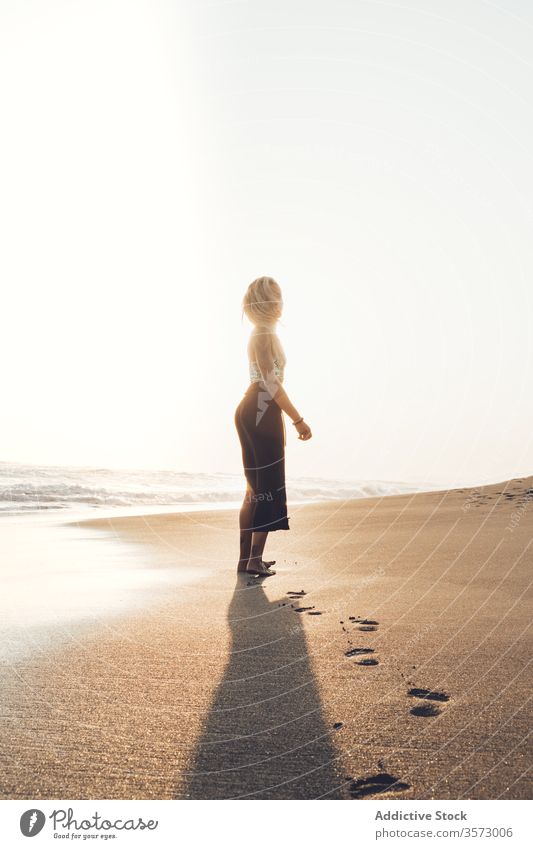 Schlankes junges Weibchen am feuchten Sandstrand stehend Frau Meereslandschaft Harmonie Einsamkeit Frieden winken Hipster nass MEER allein Küste Windstille