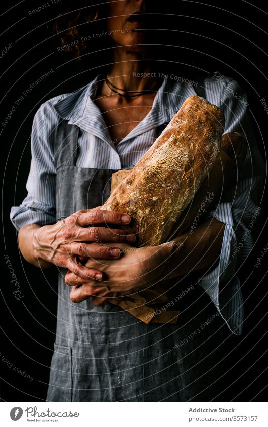 Anonyme Frau mit Ciabattabrot in der Hand Person Halt Mehl Frühstück Schürze Küche Bäcker Bäckerei Teigwaren Kunstgewerbler Verkäufer gebacken frisch Gesundheit