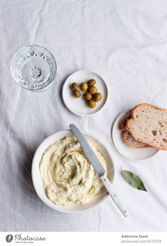 Kabeljau-Brandade in der Nähe von Oliven, Brotscheiben und Lorbeerblättern Gastronomie typisch mediterran Abendessen Mittagessen vertikal gestampft