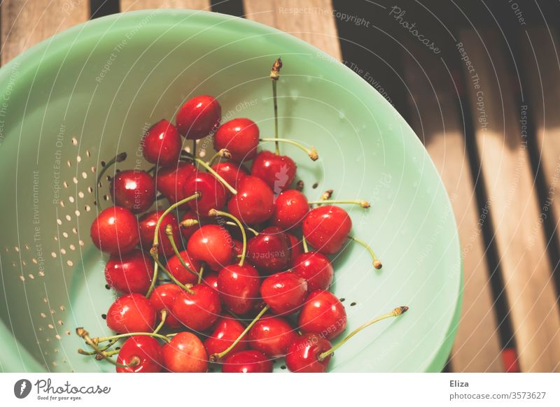 Gewaschene Kirschen in einem türkisen Küchensieb rot lecker gesund gewaschen abtropfen Sommer reif Ernte