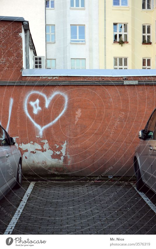 Parkplatz mit Herz Parkplatzsuche Parkplatzmangel Gebäude Mauer Haus parking reserviert Zeichen Parkplatz leer privatparkplatz Verkehr parken autos Auto KFZ