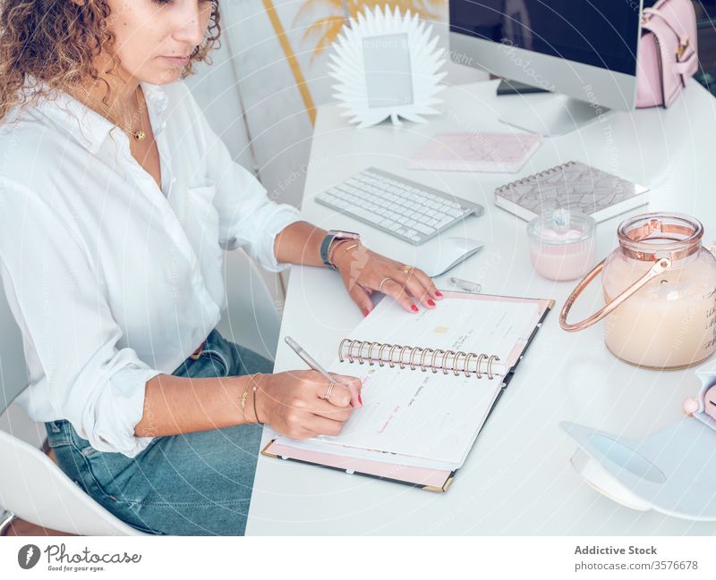 Getreide-Geschäftsfrau macht Notizen im Notizblock Frau schreibend Notebook Büro Sitzen Schreibtisch Business Arbeit Tisch palma de mallorca Spanien Stil