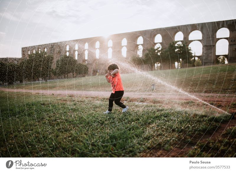 Mit Wassersprinklern spielende Kinder bestäuben Sommer Sommerurlaub Kinderspiel Kindheit Außenaufnahme Spielen Farbfoto Ferien & Urlaub & Reisen Freude