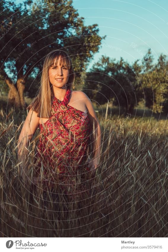 Junge Frau lacht und lächelt auf dem Feld. In den Sommerferien bei Sonnenuntergang die Natur genießen. sexy Feiertag Sommerfeld jung Schönheit schön Frieden