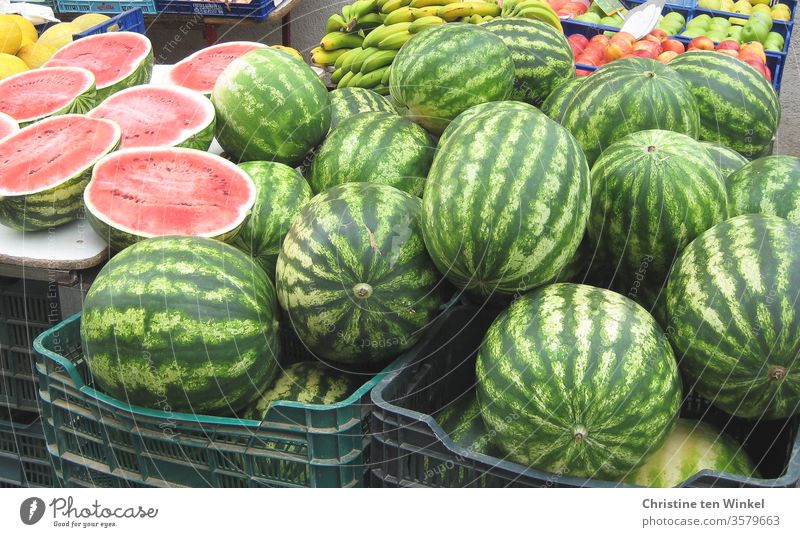 Wassermelonen in Körben an einem mediterranen Marktstand. Im Hintergrund Bananen und Äpfel Melonen Früchte Obst Markstand Ernährung Sommer Lebensmittel lecker