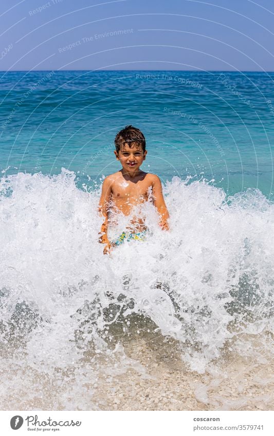 Lustiges Kind inmitten einer Riesenwelle aktiv Aktivität Strand schön Junge Kaukasier Tropfen Emotion emotional genießend Genuss Gesicht Frau schäumen Spaß