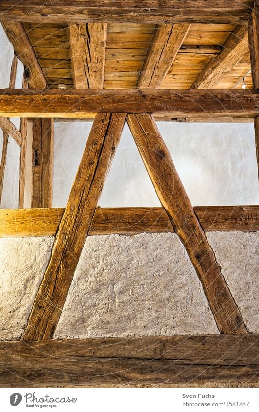 Holzbalken im Innenbereich eines Gebäudes. Holzbalkenkonstruktion in "A"-Form holzbalken ständerwerk holzdecke altbau sanierung renovierung fachwerk design wand