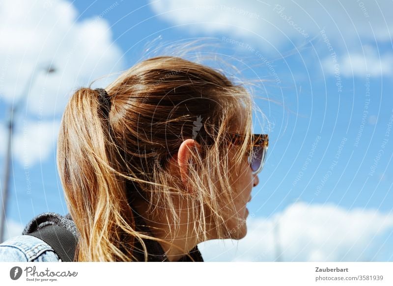 Frau mit Pferdeschwanz und Sonnenbrille schaut nach hinten schön brünett Himmel Wolken Mensch feminin langhaarig Erwachsene Hinterkopf umdrehen Ohr Strähnen