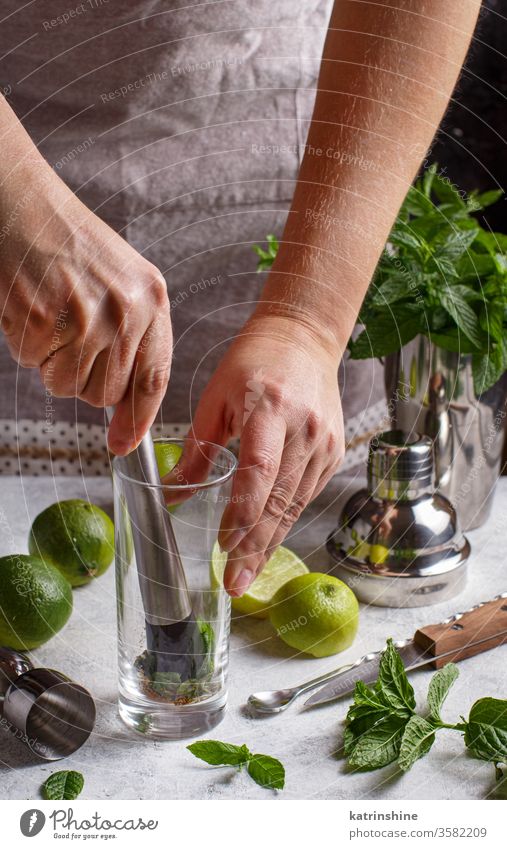 Hände, die Mojito-Cocktail mit den Werkzeugen eines Barkeepers herstellen Mocktail Minze gesichtslos Kalk Caipiroska Caipirinha Glas Herstellung Vorbereitung