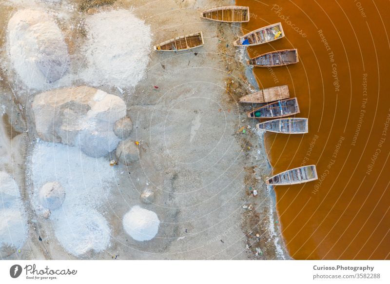 Luftaufnahme der kleinen Boote zum Salzsammeln am rosa Retba- oder Lac Rose-See im Senegal. Foto von Drohne von oben gemacht. Afrikanische Naturlandschaft.