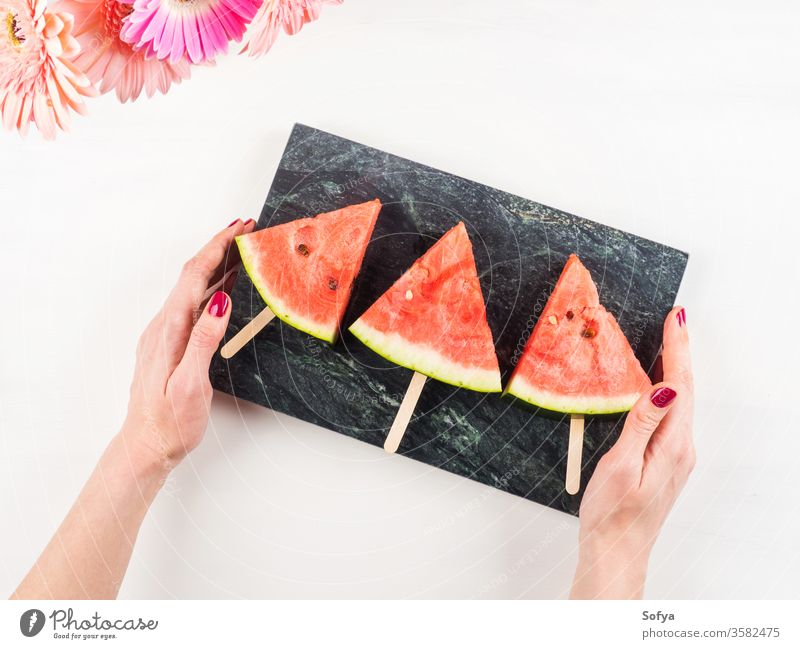 Wassermelonenscheibe Eis am Stiel auf Marmortablett Stieleis Sommer Scheiben Murmel Hand rosa Frau Tablett weiß hölzern Tisch frisch Snack Beeren Blumen lecker