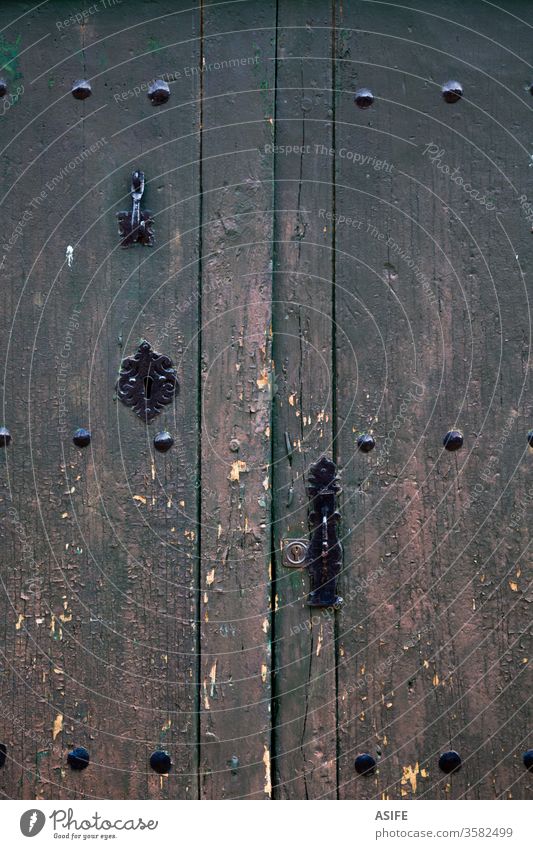 Alte rustikale Holztür mit verschiedenen Schichten rissiger Farbe Tür alt gemalt Vorderseite ländlich zugeklappt hölzern grau grün dunkel rosa antik Antiquität