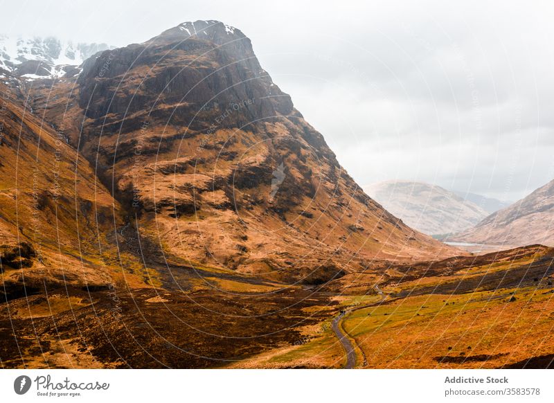 Abgelegene Straße in endlosem Gebirgstal Berge u. Gebirge Tal Hochland Felsen Natur Landschaft Route Kamm Ambitus Gelände Schottland Glen Coe Himmel wolkig Gras