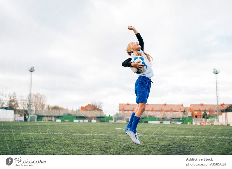 Fröhliche junge Spielerin freut sich über den Erfolg beim Fussballspielen im Sportstadion Mädchen Fußball gewinnen Kind Ball feiern Tor Sieg Glück Feld Triumph