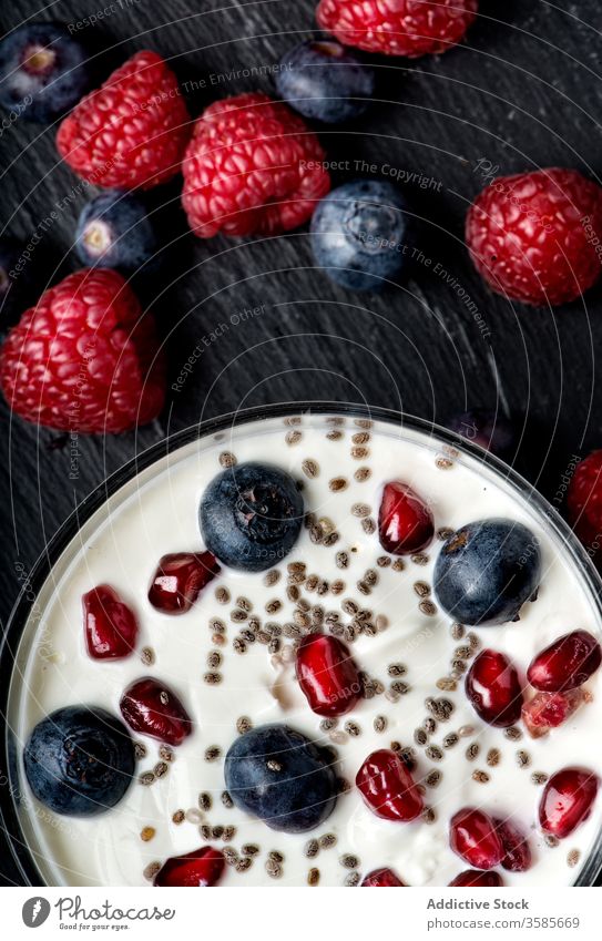 Schale mit Joghurt mit verschiedenen Beeren und Kernen Samen Frühstück Molkerei lecker gesunde Ernährung süß Himbeeren Blaubeeren Granatapfel