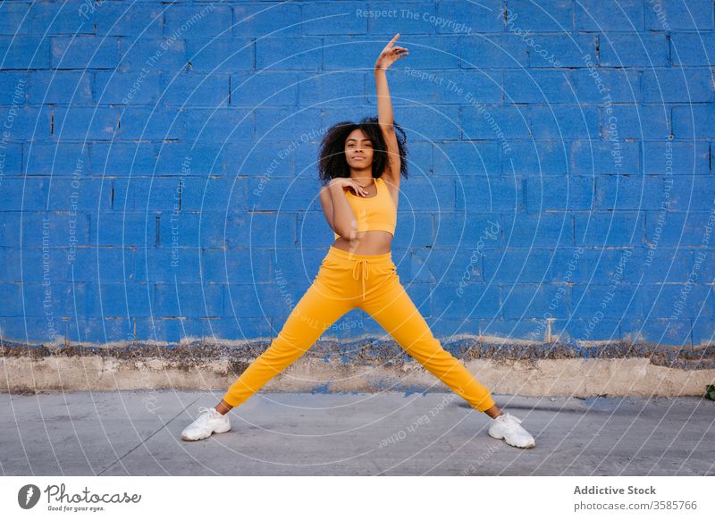 Fröhliche afroamerikanische Frau mit Afro-Frisur in Tanzpose Tanzen Pose sich[Akk] bewegen lebhaft pulsierend heiter Lächeln Bewegung Farbe schwarz ethnisch