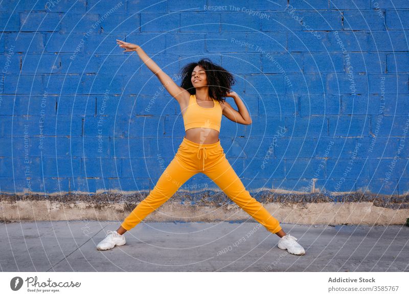 Fröhliche afroamerikanische Frau mit Afro-Frisur in Tanzpose Tanzen Pose sich[Akk] bewegen lebhaft pulsierend heiter Lächeln Bewegung Farbe schwarz ethnisch