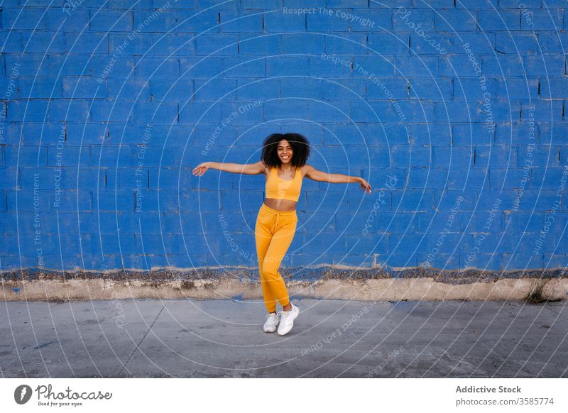 Fröhliche afroamerikanische Frau mit Afro-Frisur in Tanzpose Tanzen Pose sich[Akk] bewegen lebhaft pulsierend heiter Lächeln Bewegung Farbe schwarz ethnisch