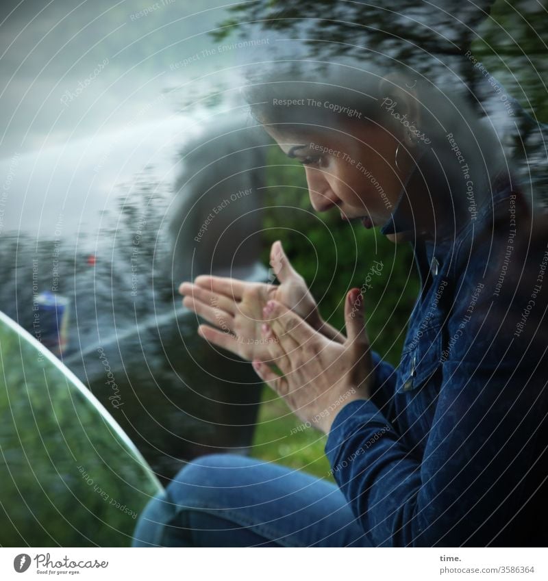 Estila frau beobachten spiegel soiegelung reflexion hände hände reiben baum jeans jacke aufmerksam ohrring profil glasscheibe