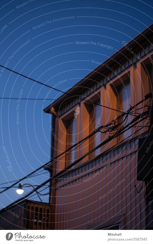 Gebäude mit Telefonkabeln in der Blauen Stunde Blaue Stunde Architektur wohnbedingt Haus modern Fenster Außenseite blau Himmel Nacht Abenddämmerung