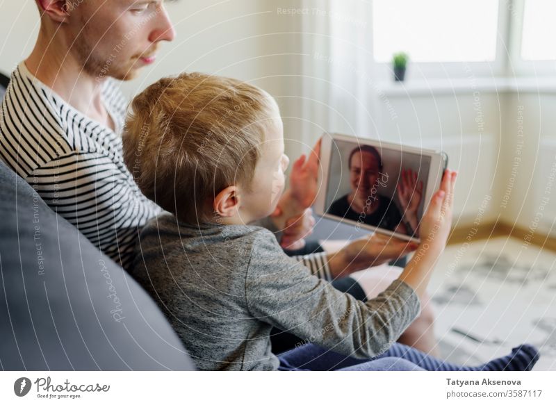 Vater und Sohn führen Videoanruf bei der Mutter Anruf Familie Internet Technik & Technologie modern Menschen heimwärts Talkrunde Computer Mitteilung Frau jung