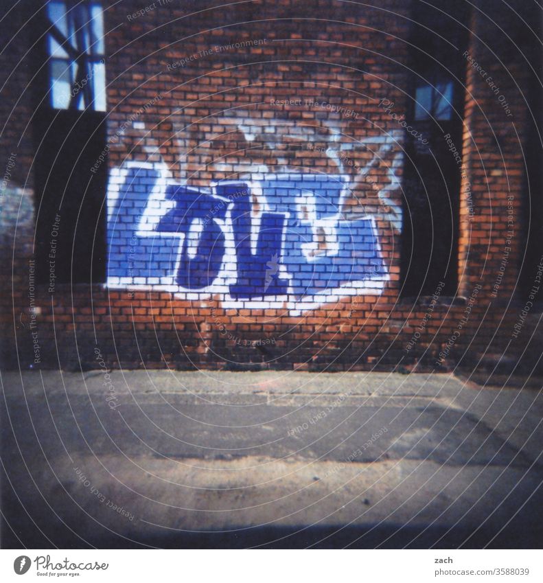 Aufschrift Liebe an einer Backsteinfassade, Graffiti, analog Dia Stadt Haus Himmel düster cross Cross Processing Experiment Holga Lomografie Scan Ruine