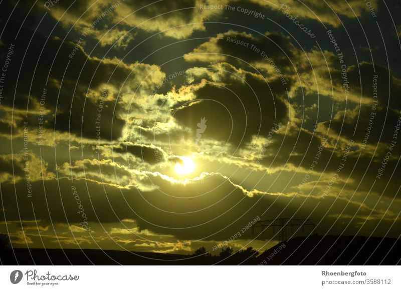 Sonnenuntergang hinter dunklen Wolken Licht Dunkel Hell Wetter Abend Abenddämmerung Energie Stom Strommast Leuchten Himmel Horizont horizontal