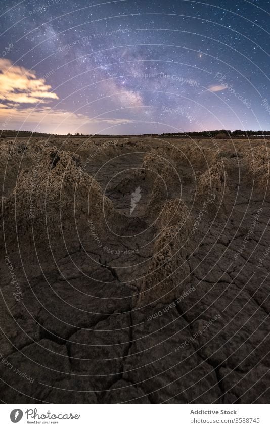 Anonyme Person steht in sternenklarer Nacht auf felsigem Terrain Mann Felsen Gelände Milchstrasse Fackel Silhouette Landschaft vulkanisch porig malerisch Himmel