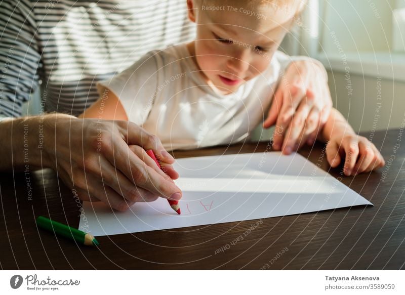 Vater lehrt Kind schreiben oder zeichnen Bildung heimwärts Lehre Homeschooling Schule schreibend Lernen Hausaufgabe Lehrer Menschen Sitzen Eltern Familie