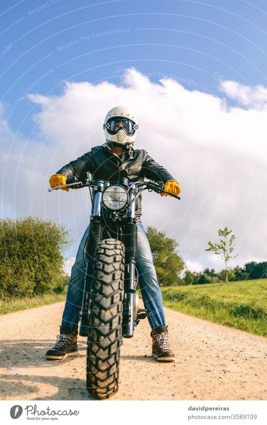 Mann mit Helm auf einem Custom-Motorrad Blick von unten Biker benutzerdefiniert altehrwürdig Rad Fahrrad retro Reiter Fahrzeug Verkehr posierend jung