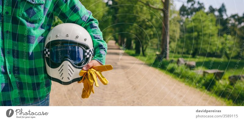 Mann posiert mit Motorradhelm und Handschuhen unkenntlich kariertes Hemd Straße Transparente Netz panoramisch Panorama altehrwürdig cool retro Reiter Biker Mode