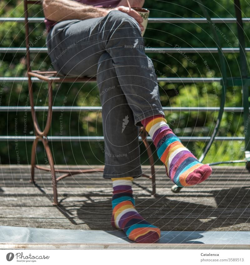 Haute Couture |  abgehobenes Modebewusstsein; knallige Ringelsocken Mann Beine Füsse Bekleidung Trend Fuß Strümpfe Mensch sitzend Stuhl Balkon Sommer bunt