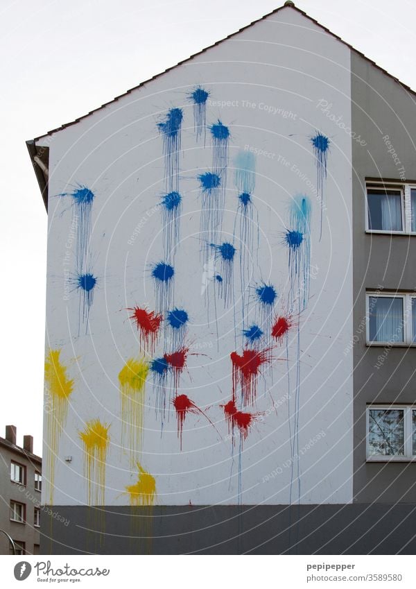 Farbbeutel auf eine Hausfassade geworfen Fassade Fenster Außenaufnahme Wand grau Bauwerk Gebäude Mauer Farbfoto Menschenleer Farbe Himmel weiß trist blau gelb