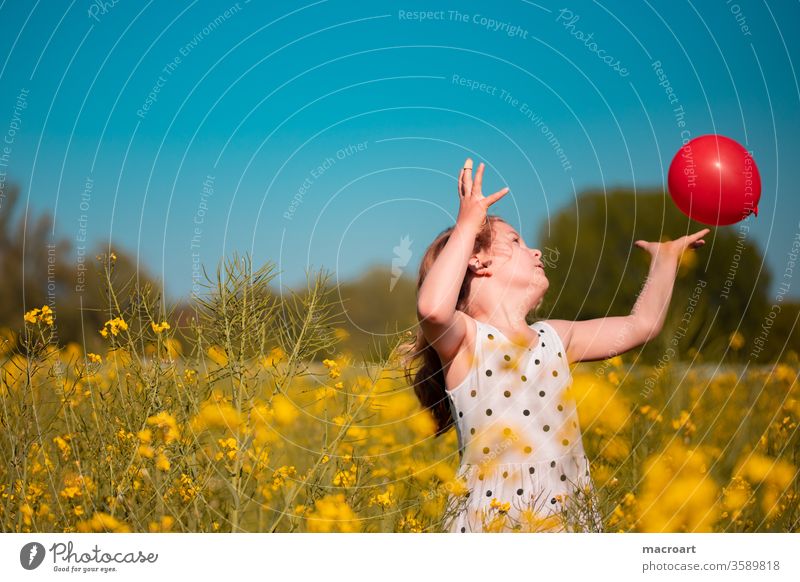 Kind im Rapsfeld mädchen kind spielen ballon greifen fangen weise blühen blühend blütem blumen floral natur feminin kelid blond lockenkopf hände