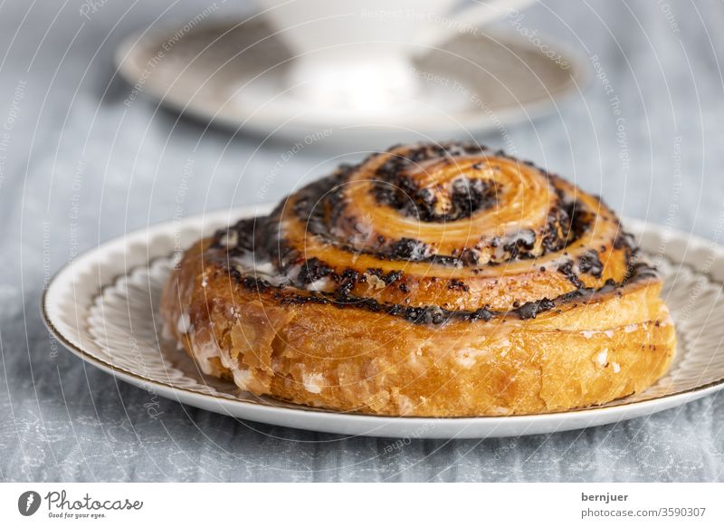 Nahaufnahme eines Mohnstrudels Mohnschnecke Gebäck Kaffeeteilchen Strudel niemand trinken Teller Zucker Keks Dessert Essen hausgemacht lecker traditionell braun