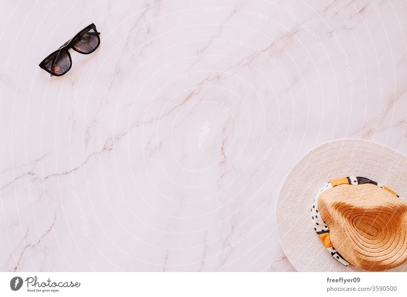 Flache Anordnung von Objekten aus den Bereichen Sommer, Frühling und Freizeit vor einem Marmorhintergrund Sonnenbrille Hut flache Verlegung Flachlegung