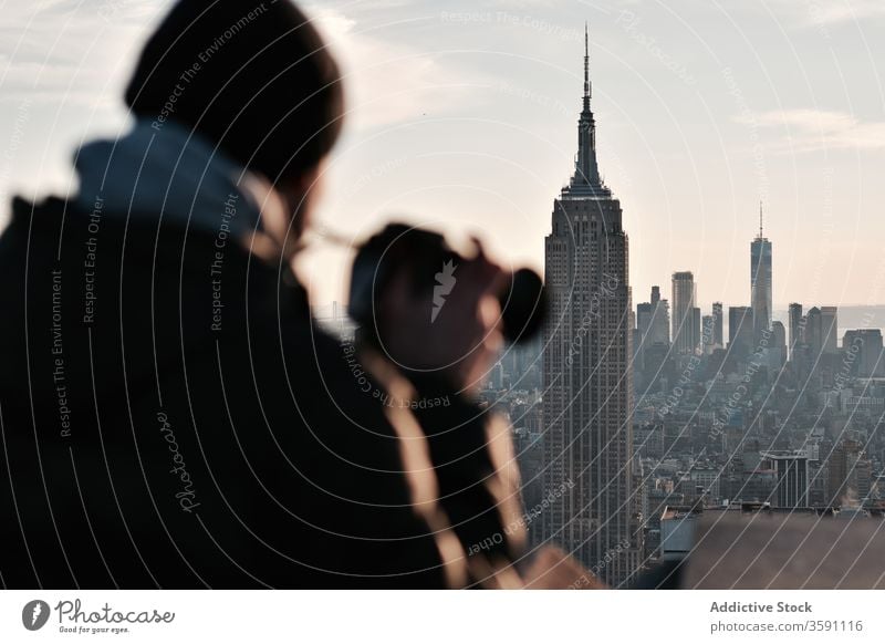 Männlicher Fotograf bewundert Stadtlandschaft mit Wolkenkratzern Reisender Stadtbild Mann bewundern Fotoapparat Sonnenuntergang Großstadt Moment männlich