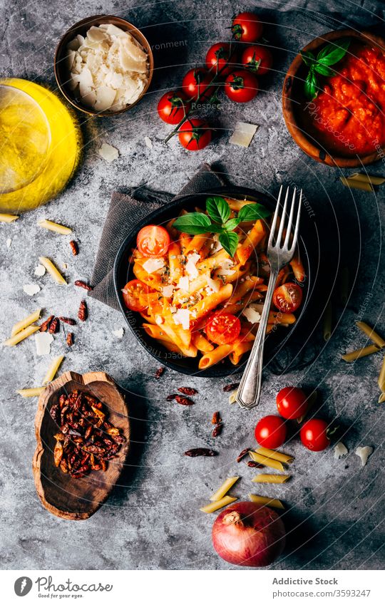 Appetitliche Penne mit Arrabiatasauce und frischen Tomaten auf dem Tisch Spätzle Gastronomie arrabiata Saucen Bestandteil Parmesan Italienisch Tradition