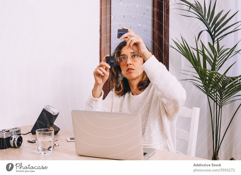 Fotograf mit Dias, der zu Hause arbeitet Arbeit heimwärts Sliden Laptop Frau retro Beruf kreativ jung Arbeitsplatz Fotoapparat Apparatur digital Gerät