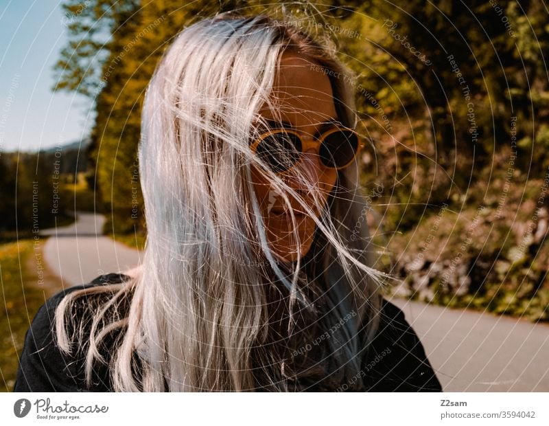 Modische Junge Frau beim Spaziergang spaziergang natur landschaft grün sommer sonnebrille retro blond lange haare schön hübsch jung jugendlich lifestyle lachen