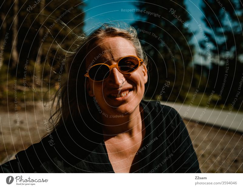 Modische Junge Frau beim Spaziergang spaziergang natur landschaft grün sommer sonnebrille retro blond lange haare schön hübsch jung jugendlich lifestyle lachen