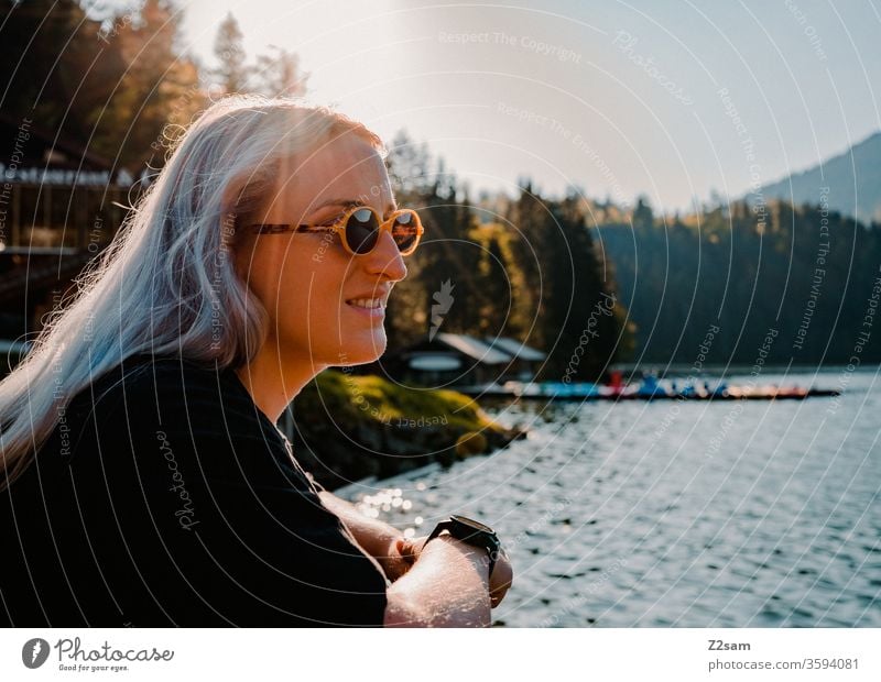 Junge Frau am Spitzingsee natur landschaft grün sommer sonnebrille retro blond lange haare schön hübsch jung jugendlich lifestyle lachen lächeln wehen wind