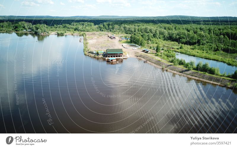 Luftaufnahme des Flusses Kama, Perm krai, Russland. Ländliche Landschaft von oben, Wellen und Kräuseln im Wasser, Wolkenspiegelung im Wasser, Bäume an der Küste, Sommersonnentag. Raum kopieren.