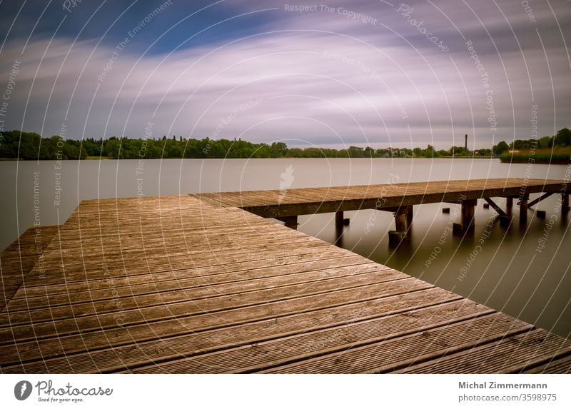 Steg an einem See Seeufer Wasser Wasseroberfläche grün Holz Natur Naturliebe Naturerlebnis Frühling Außenaufnahme Menschenleer Landschaft Farbfoto