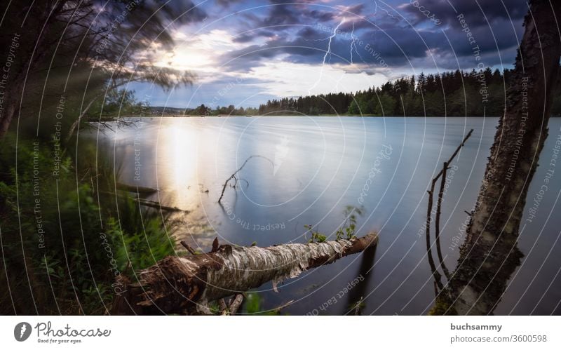 Sonnenuntergang an einem See mit gleichzeitig aufziehendem Gewitter und Blitzen. Landschaft sehen Gewässer Himmel dramatisch wolken feuchter blitze Unwetter